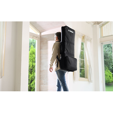 Photo of a person walking with the SC-KB650 keyboard bag for Yamaha Arranger Workstation PSR-SX series and PSR-E400 series on his back.