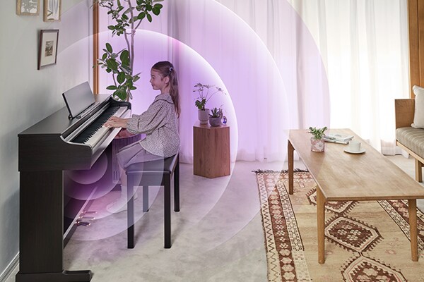 Der ausdrucksstarke Anschlag der neuen ARIUS Tastatur und Schallwellen, die von einem ARIUS Piano in einem Wohnzimmer ausgehen
