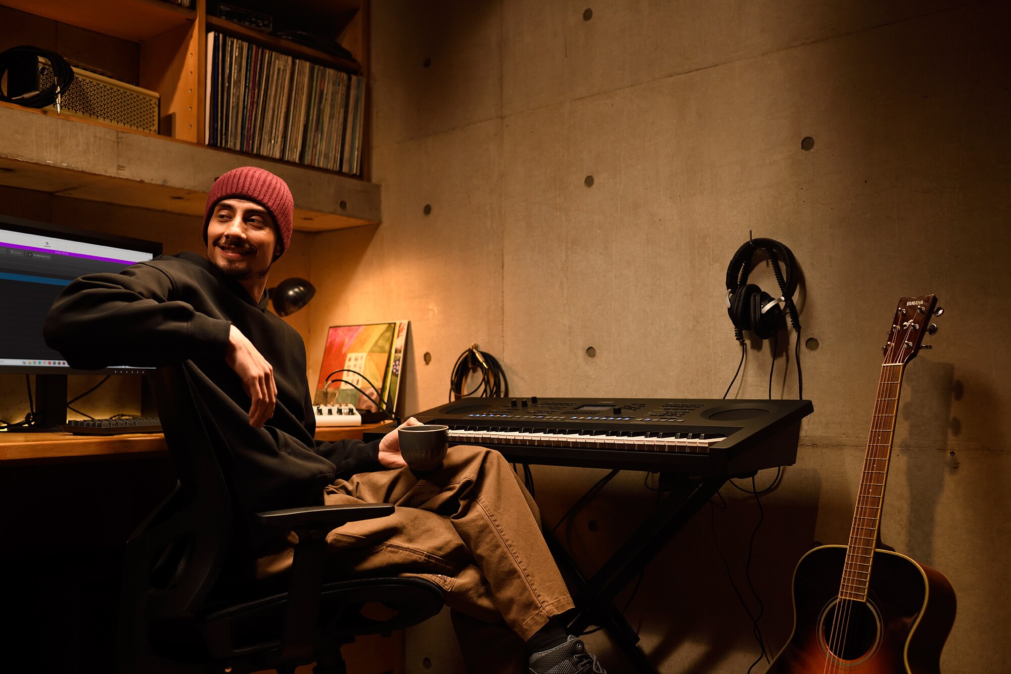 Ein Musik-Arbeitsplatz zu Hause mit einem Computer und einem Keyboard, an dem ein Keyboarder in seinem Heimstudio arbeitet