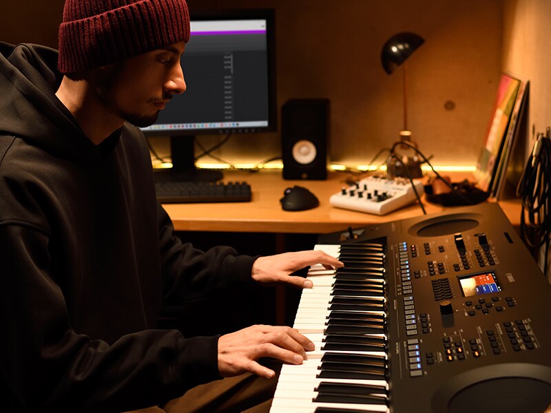 Eine Person spielt ein PSR-SX620-Keyboard in einem Heimstudio.
