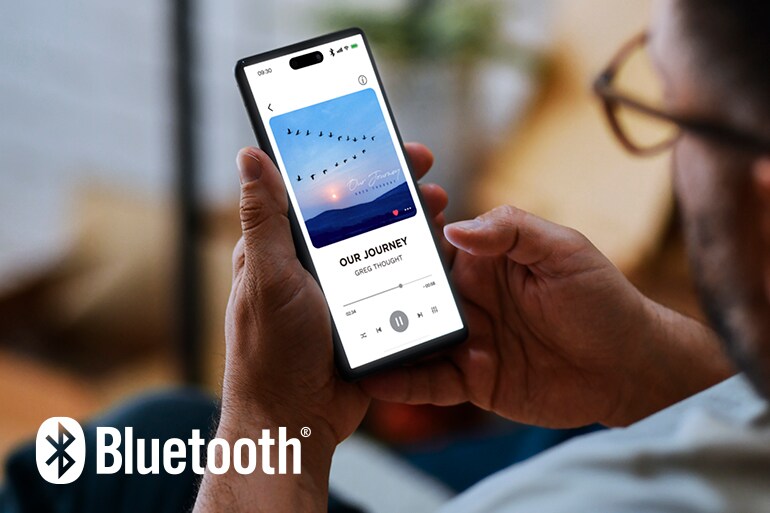 Das Bluetooth-Logo und ein Mann, der ein Smartphone zur Musikwiedergabe nutzt.