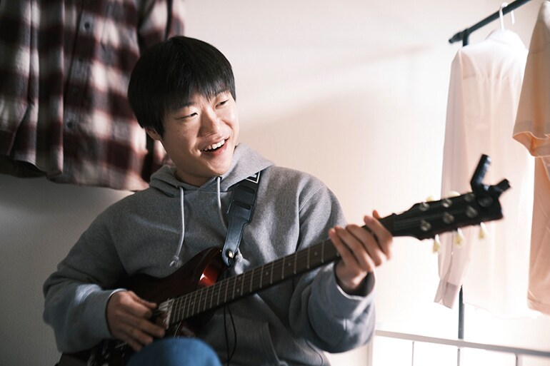 Ein Mann, der zum ersten Mal versucht, Gitarre zu spielen