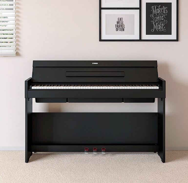 Ein Wohnzimmer mit einem schwarzen ARIUS Piano, das neben Wandregalen mit Lampen und einem Diffusor steht und harmonisch in die Einrichtung integriert ist.